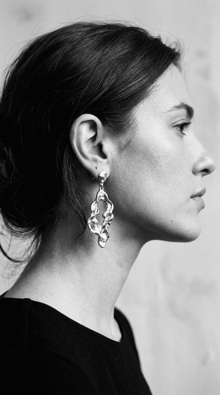 Black and white portrait of sculptural silver drop earrings
